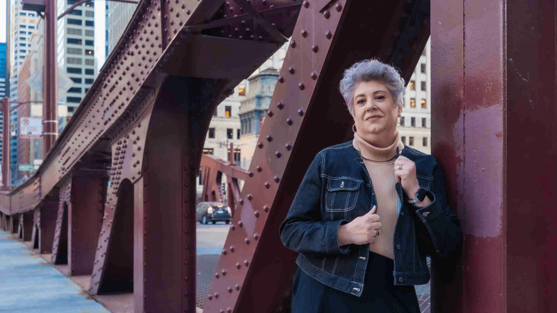 Professional woman standing confidently in an urban setting representing resilient leadership and aligned success