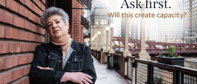 Lisa Olinda beside a brick wall overlooking a city riverwalk. Text reads, “Ask first. Will this create capacity?